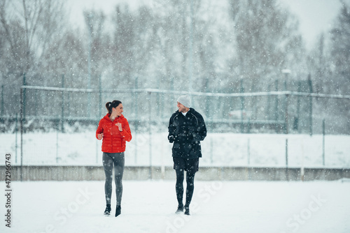 Young couple going for a run together during a snow
