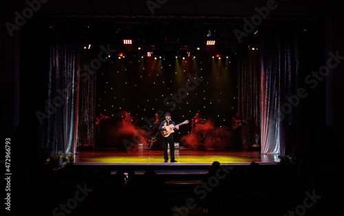 A team of musicians, singers and dancers in gypsy costumes singing and dancing on stage photo