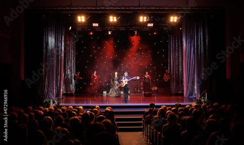 A team of musicians, singers and dancers in gypsy costumes singing and dancing on stage photo