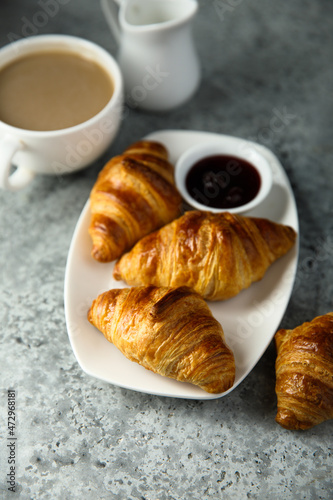Traditional homemade French croissants with coffee and jam