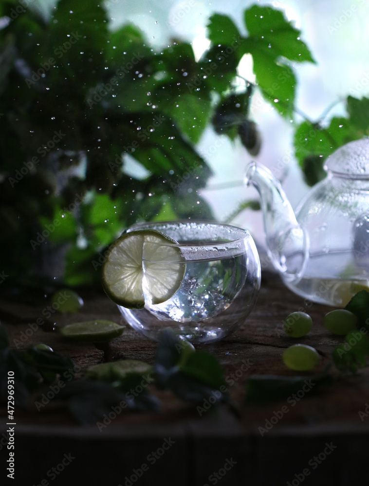 Atmospheric photo of a teapot and a mug with green tea on a wooden table