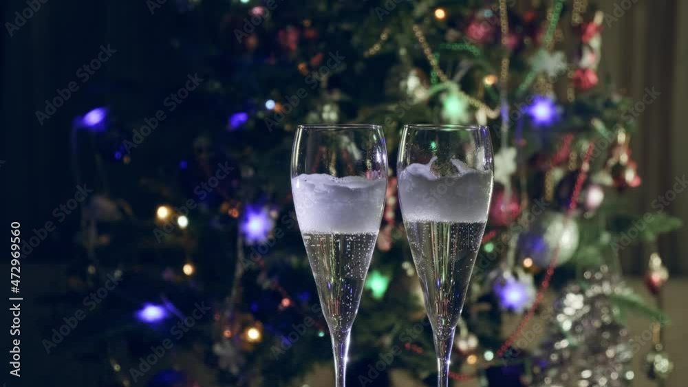 Champagne glass close up on Christmas and New Year holiday bokeh background. Two glasses with bubbly tasty sparkling drink. Happy New Year! Celebrating winter holidays, 4K, close up, macro Champagne glass close up on Christmas and New Year holiday bokeh background. Two glasses with bubbly tasty sparkling drink. Happy New Year! Celebrating winter holidays, 4K, close up, macro