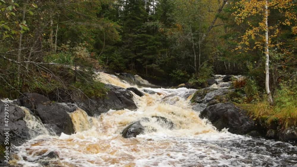 Tohmajoki Waterfall on an autumn day. Stormy streams of red water. Nature of Karelia, Russia Tohmajoki Waterfall on an autumn day. Stormy streams of red water. Nature of Karelia, Russia