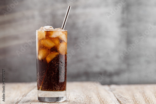 Cola with Ice Cubes. Glass of cola with ice cubes on wood table, soft drink.