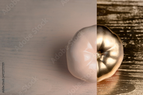 Gold and beige or ecru half painted tomato on golden and wooden background.