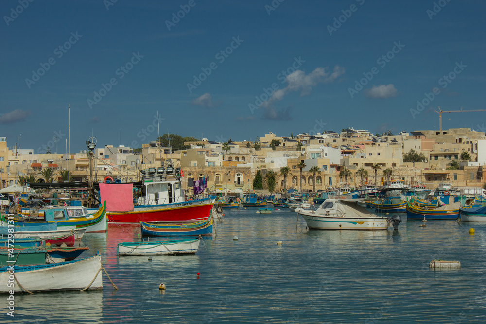 Port town with old buildings and waterfront in late summer in Malta, Marsaxlokk