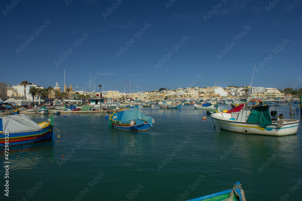 Port town with old buildings and waterfront in late summer in Malta, Marsaxlokk
