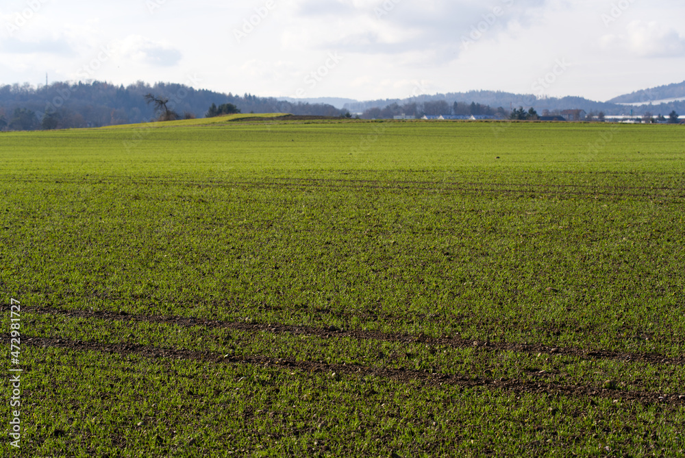 Beautiful scenic landscape with close-up of agricultural field in the foreground on a cloudy winter day. Photo taken December 3rd, 2021, Oberglatt, Canton Zurich, Switzerland. Beautiful scenic landscape with close-up of agricultural field in the foreground on a cloudy winter day. Photo taken December 3rd, 2021, Oberglatt, Canton Zurich, Switzerland.
