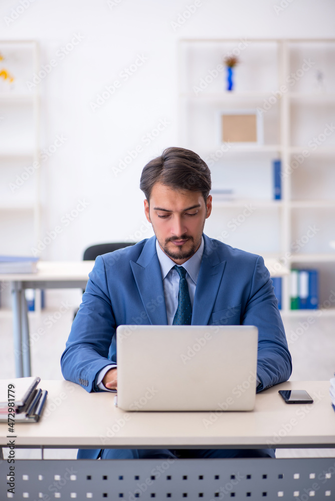Young male employee working in the office Young male employee working in the office