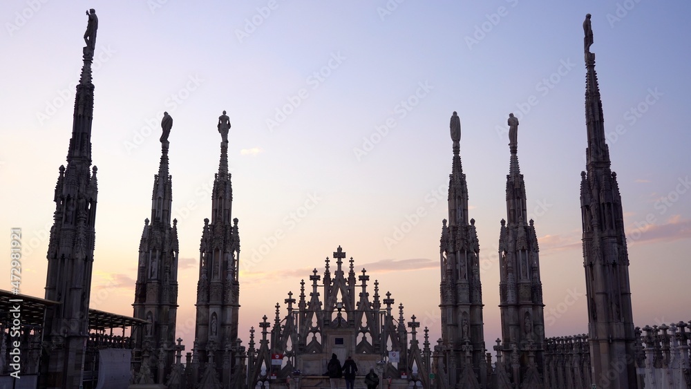 Europe , Italy , Milan December 2021 - 
the Madonnina of Duomo with its typical spiers, aerial view of the city skyline  at sunset