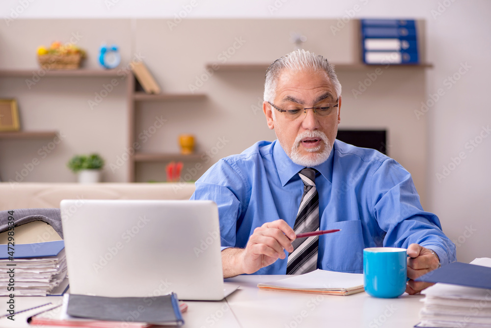Old male employee working from home during pandemic Old male employee working from home during pandemic