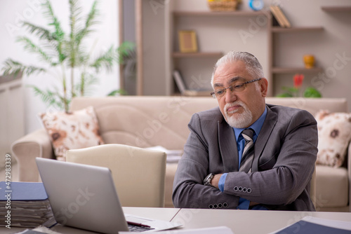 Old male employee working from home during pandemic