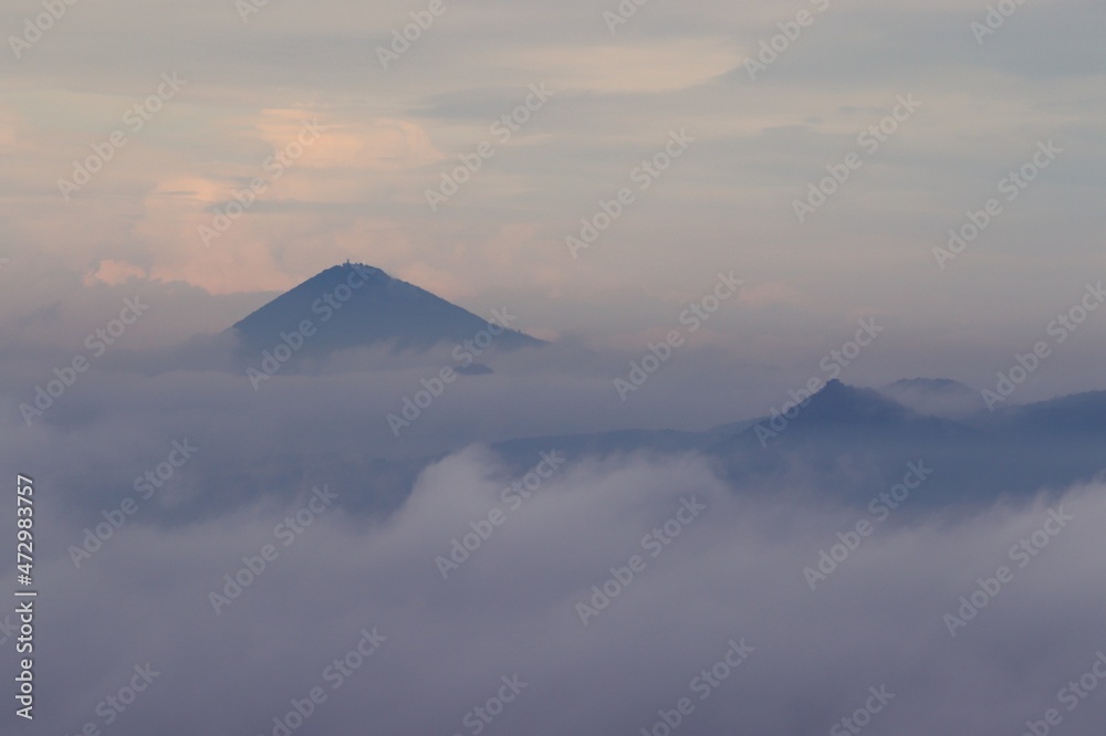 A view to the peaks of Czech Highlands during the morning fog from castle Hazmburk, Czech republic