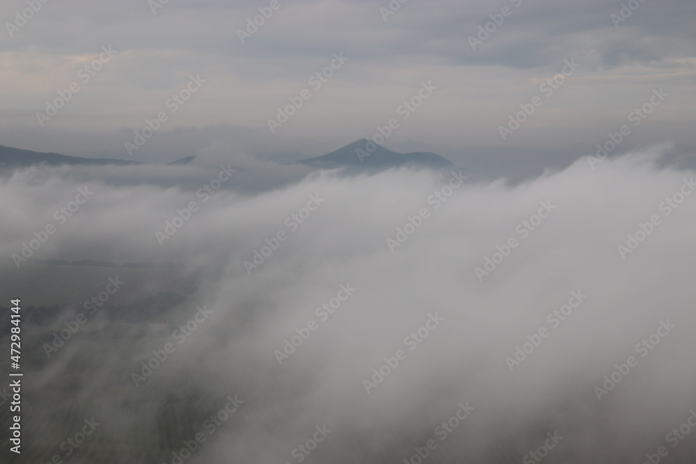 A view to the peaks of Czech Highlands during the morning fog from castle Hazmburk, Czech republic A view to the peaks of Czech Highlands during the morning fog from castle Hazmburk, Czech republic