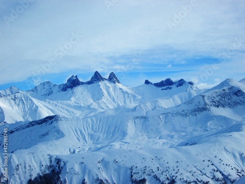 Beautiful view of high mountains in the winter. Peaks against blue cloudy sky. 