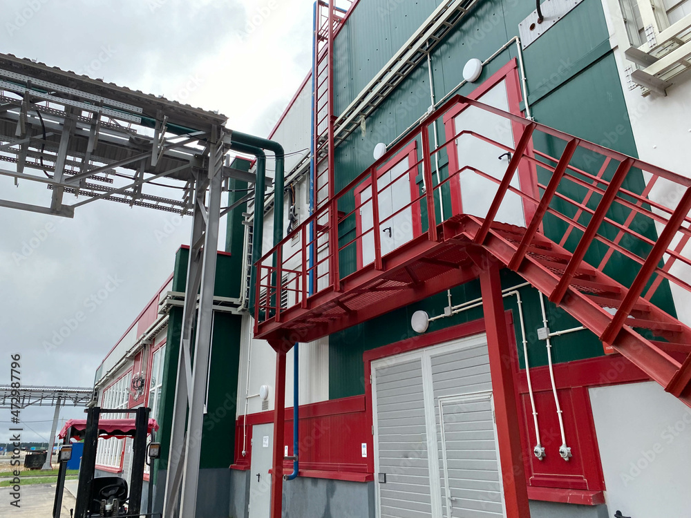 fire safety elements on the wall of an industrial building: stairs, fences, signs