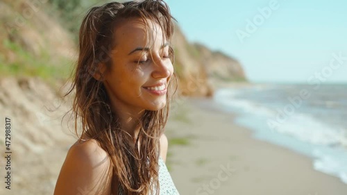 slow motion of happy joyful slim fitbody woman wearing in bikini and enjoying wind and waves on sea coast after storm. photo