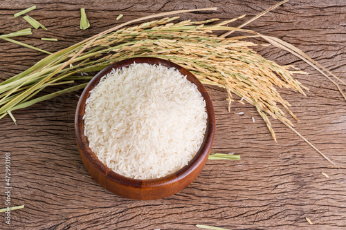 organic white rice or jasmine rice in a wooden bowl, placed on a wooden floor