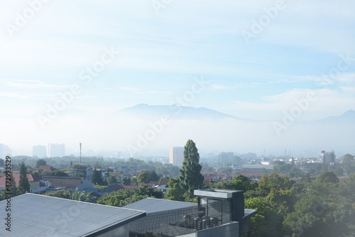 Bandung, Indonesia - May 10, 2021 : Aerial view of Bandung city, Indonesia. The view in the morning of the city of Bandung from the height of the skyscraper. © Alfian