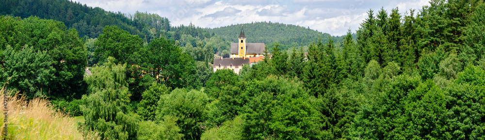 panorama of a wooden landscape with the church of a small vilage in the center in the region Waldviertel (forestquarter) Austria