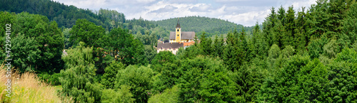 Φωτογραφία panorama of a wooden landscape with the church of a small vilage in the center i