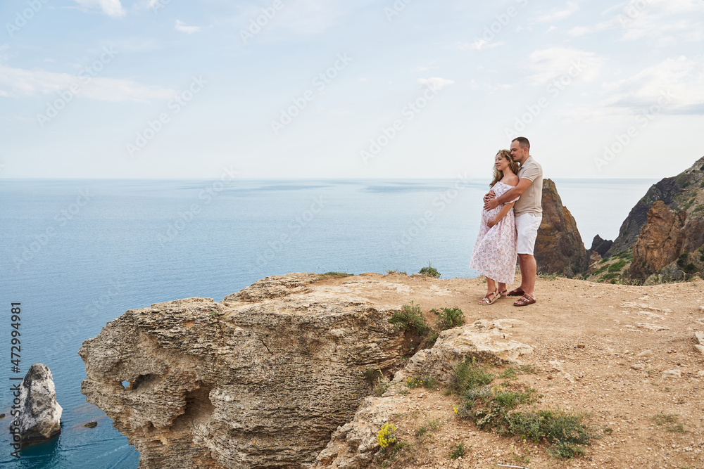 beautiful pregnant couple on the background of a beautiful sea and mountainous landscape beautiful pregnant couple on the background of a beautiful sea and mountainous landscape