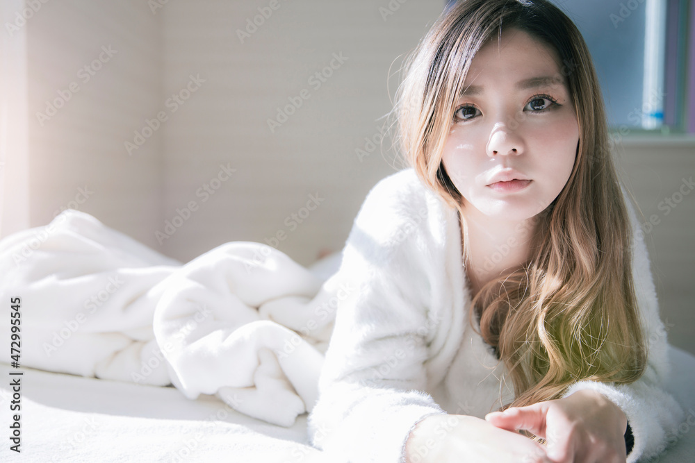 休日にベッドに横になりゴロゴロしてリラックスする爽やかな女性のポートレート 休日にベッドに横になりゴロゴロしてリラックスする爽やかな女性のポートレート