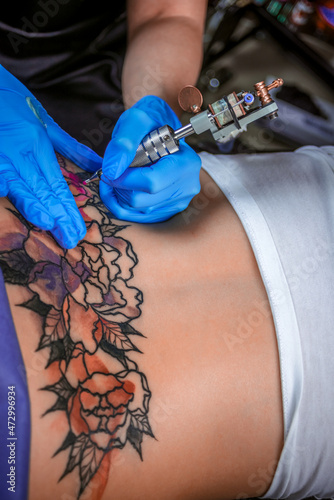 Obraz na plátně Tattoo specialist at work in tattoo studio