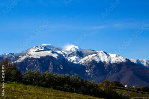 snowy mountain top before snowfall with wind blowing snow © gianni