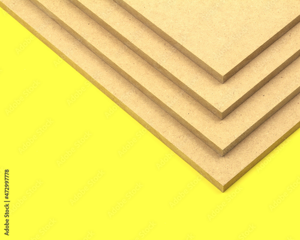 Raw mdf cut to size and stacked on top of each other, photographed on a
