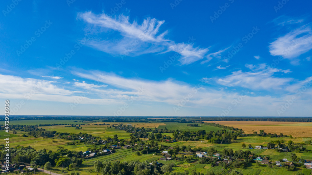 Aerial view over beautiful suburb in  wide valley, in the summer.  Top view to the small village with a beautiful green landscape.