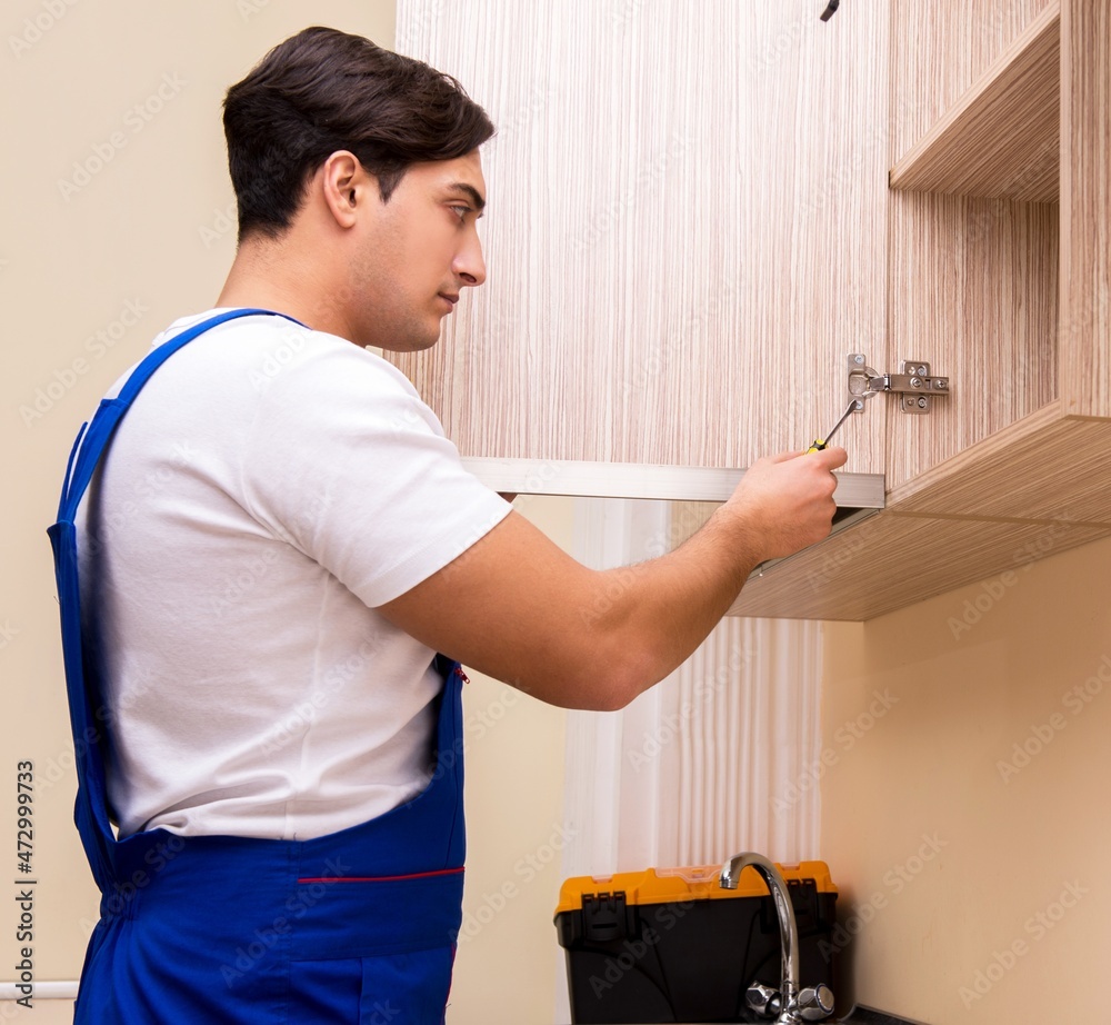 Young man assembling kitchen furniture Young man assembling kitchen furniture