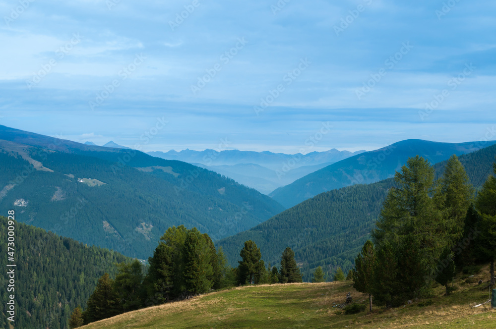 Naklejka premium Bergige Landschaft in Österreich. Blick von einem hochgelegenen Punkt auf eine Gebirgskette. Sonniger Herbsttag