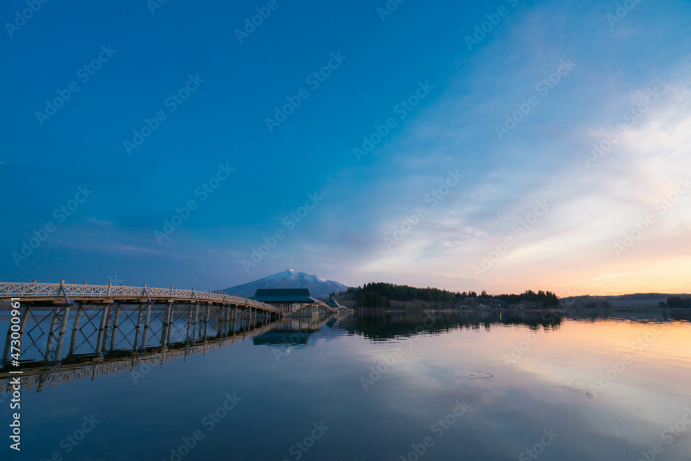 青森の長い木造橋と池のリフレクションと夕焼け