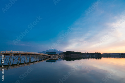 青森の長い木造橋と池のリフレクションと夕焼け © Kentaro Hashimoto