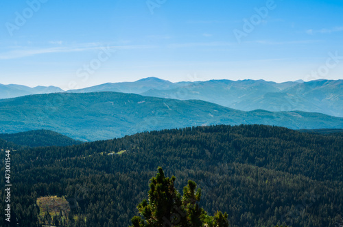 Fototapeta Naklejka Na Ścianę i Meble -  Bergige Landschaft in Österreich.  Blick von einem hochgelegenen Punkt auf  eine Gebirgskette. Sonniger Herbsttag