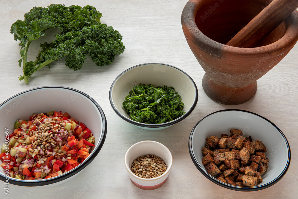 Fresh cut vegetable ingredients to make meal using clay mortar for kale leaves. Fresh cut vegetable ingredients to make meal using clay mortar for kale leaves.