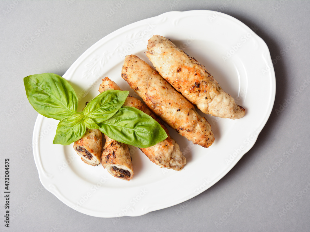 Meat roll top view with dried apricots, prunes and walnuts inside. Chicken Meat cannelloni stuffed with dried fruits and nuts. Served with fresh basil leaf on white vintage plate on gray background
Meat roll top view with dried apricots, prunes and walnuts inside. Chicken Meat cannelloni stuffed with dried fruits and nuts. Served with fresh basil leaf on white vintage plate on gray background