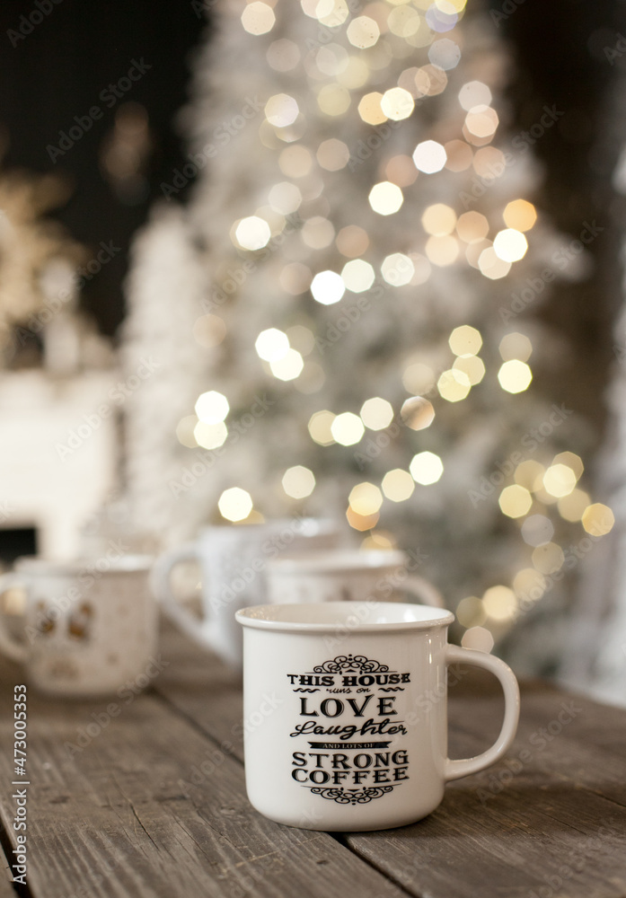 A cup of coffe with christmas tree lights bokeh as background. Holiday season coffee break. A cup of coffe with christmas tree lights bokeh as background. Holiday season coffee break.