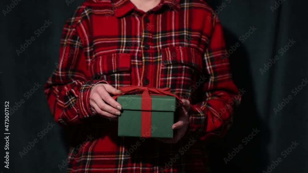 Woman in red shirt holding gift box in hands Woman in red shirt holding gift box in hands