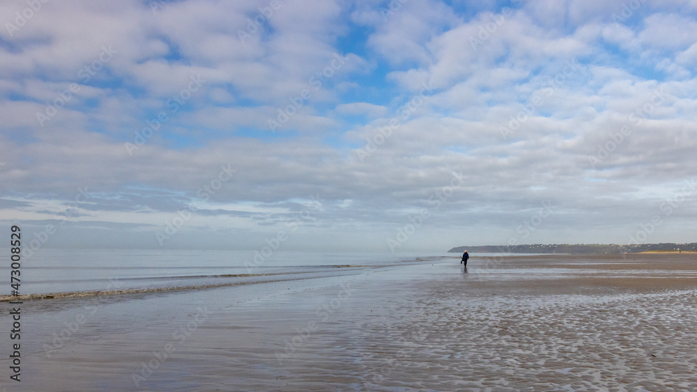 Fin de matinée sur la plage à marée basse : calme et douceur d'une promenade dans une ambiance bleutée entre ciel et mer.