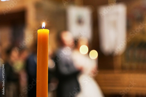 A candle is lit in the church during the wedding ceremony.
