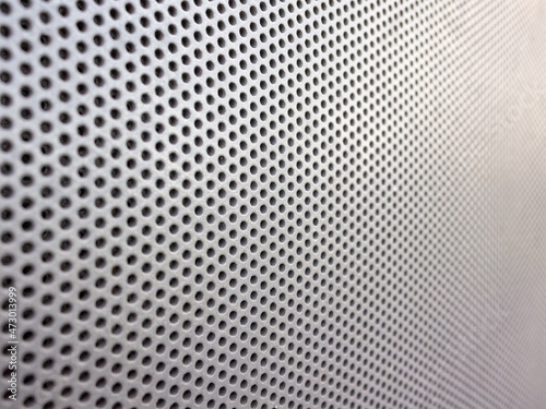 Background image of a perforated sheet metal facade