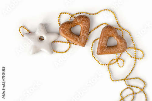 Heart and star shaped gingerbread and golden beads on white background, top view