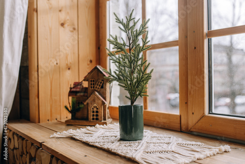 Decorative Christmas tree in a pot on the windowsill
