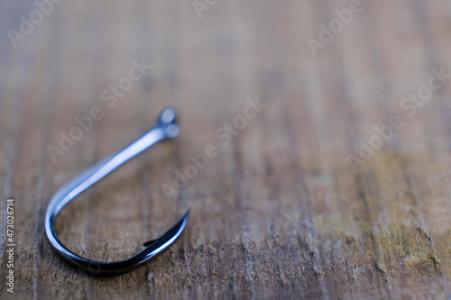 Close-up of a fishing hook. Carpfishing hook on wooden background.