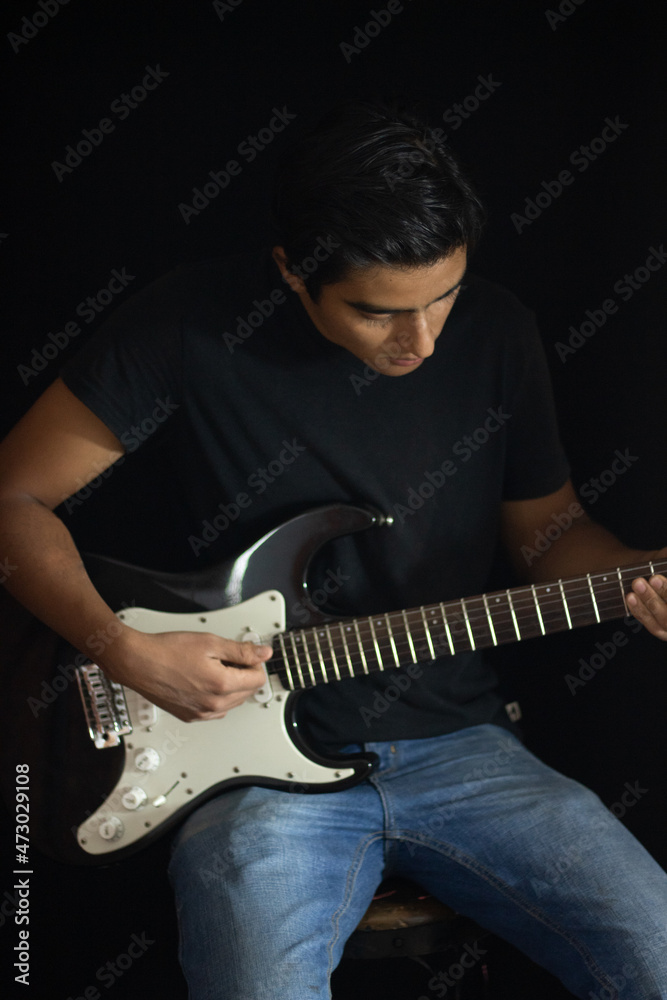Obraz premium boy playing electric guitar inside a studio