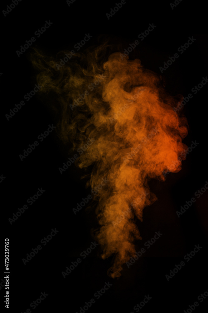 Fragment of orange magic curly steam smoke isolated on a black background, close-up. Create mystical photos.