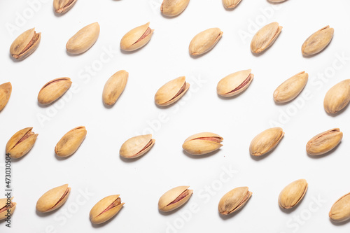 Roasted pistachio nuts pattern on white. Whole fried and dried pistachio nut