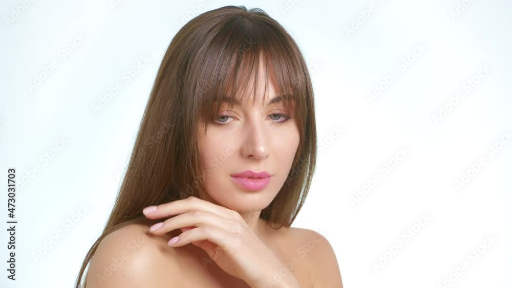 Healthy skin care concept. A beautiful young woman gently touches her body and face with her hand on a white background. Healthy skin care concept. A beautiful young woman gently touches her body and face with her hand on a white background.